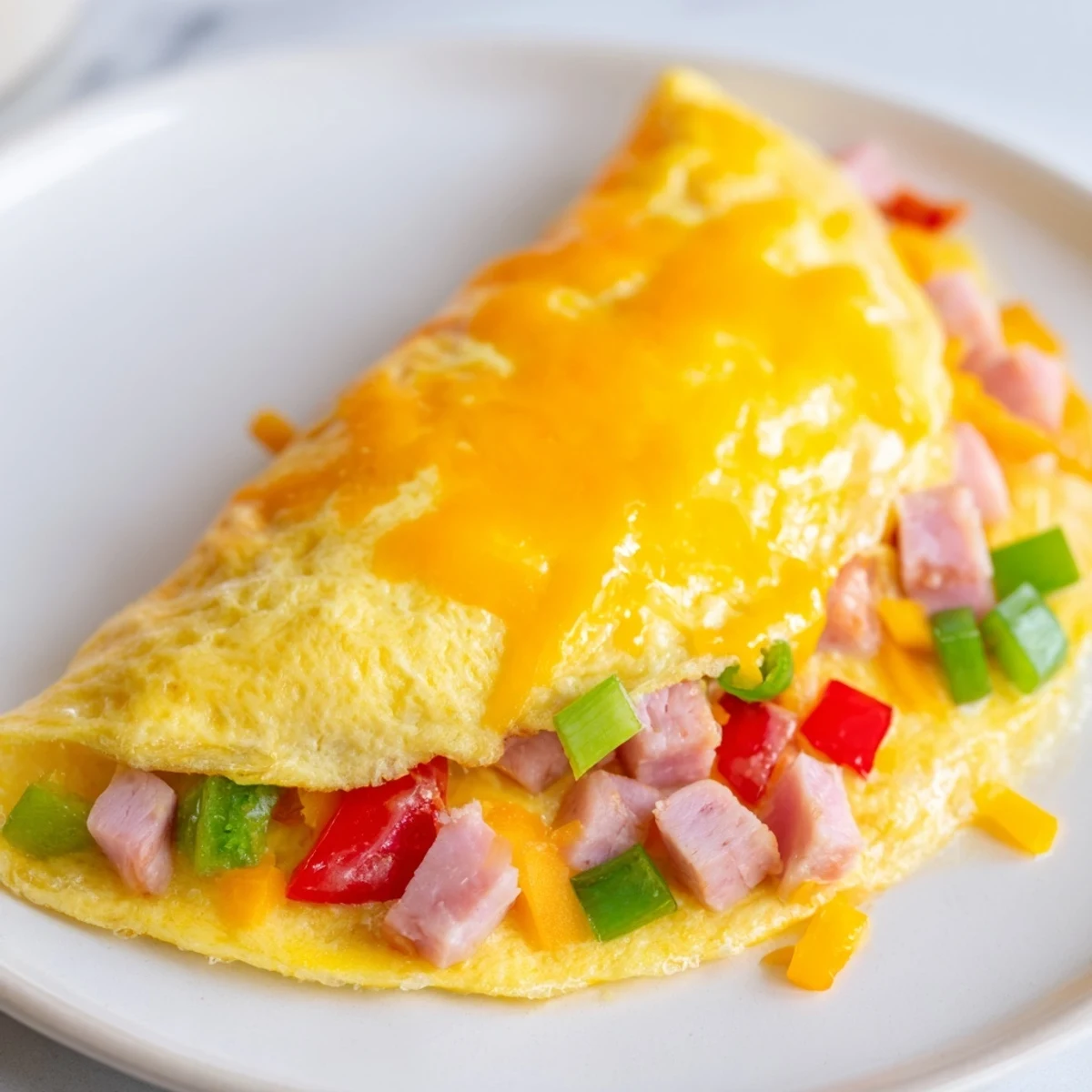 A perfectly cooked Denver Omelet, featuring tender vegetables and rich cheese, ready to be enjoyed.