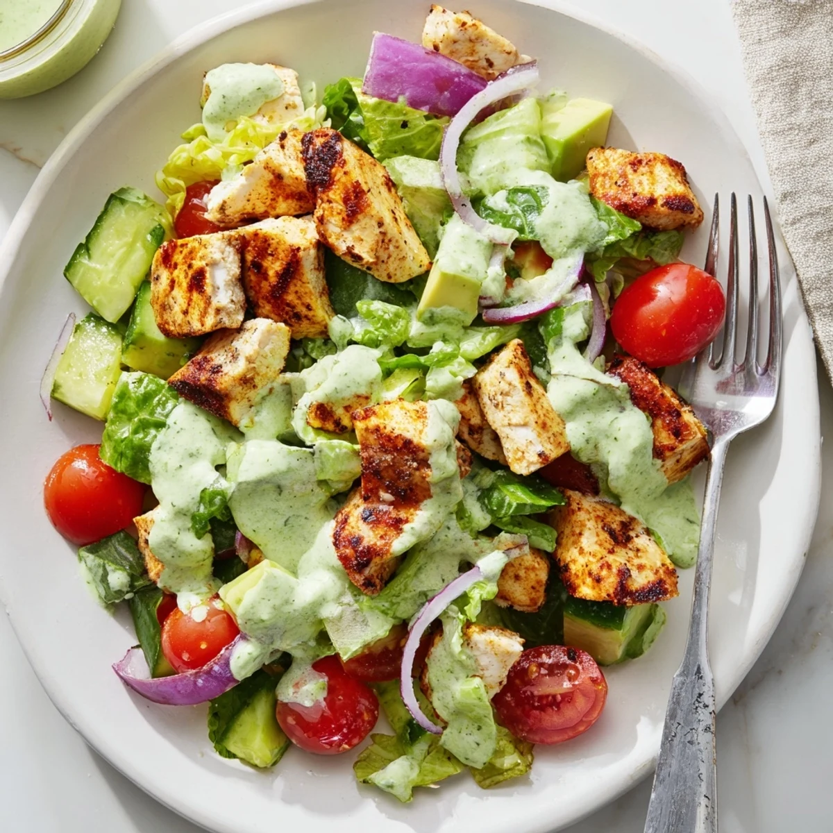 A vibrant bowl of Avocado Ranch Chicken Salad, featuring juicy diced chicken, crisp vegetables, and a rich avocado-based ranch dressing.  