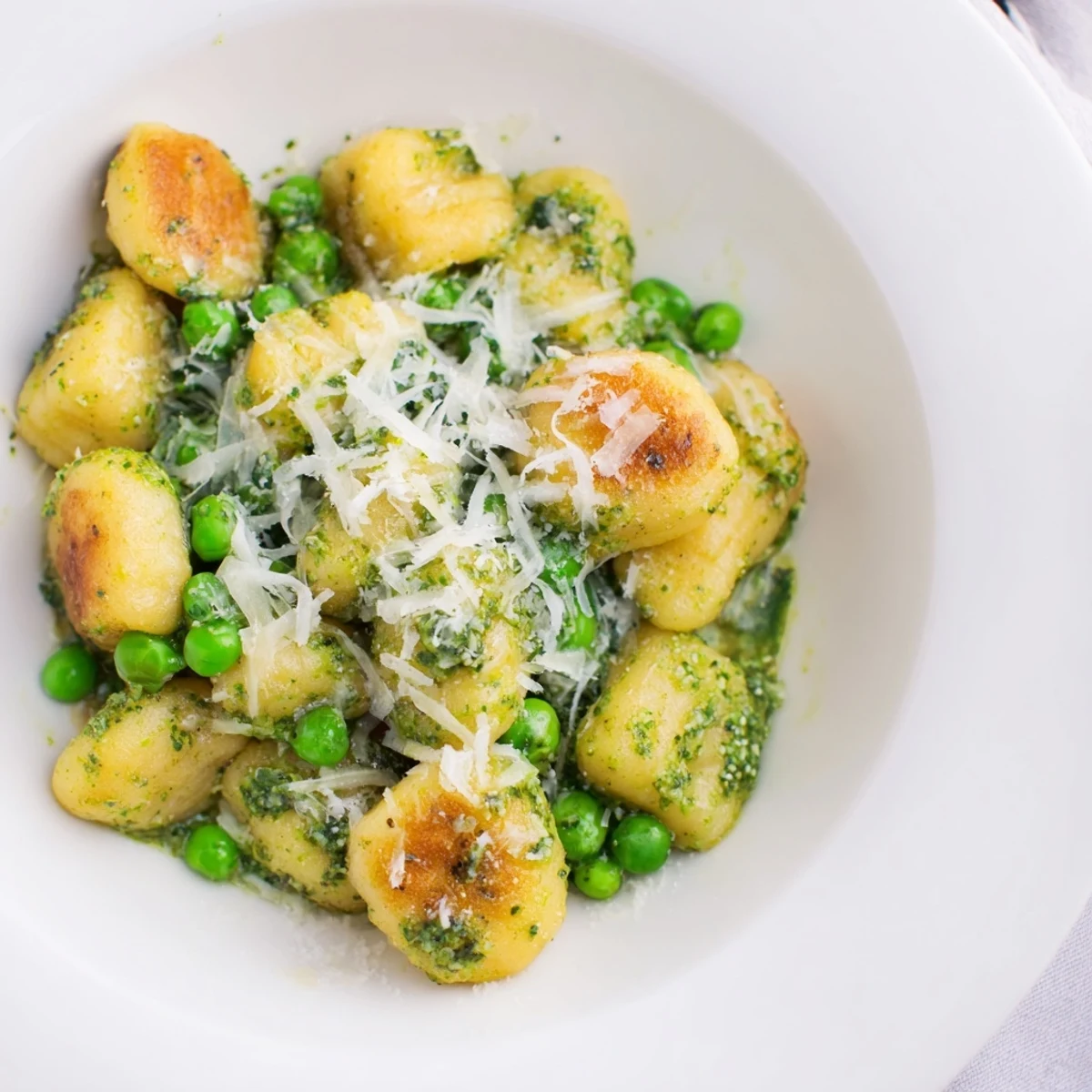 Golden, crispy pan-fried gnocchi are tossed with vibrant basil pesto and sweet green peas in this savory skillet.  