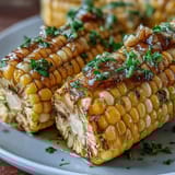 Tender corn on the cob, steamed in the microwave and coated in rich garlic butter for a quick, flavorful side dish.