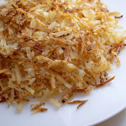 Fluffy and delicious hash browns, expertly fried to a perfect golden brown in the skillet.