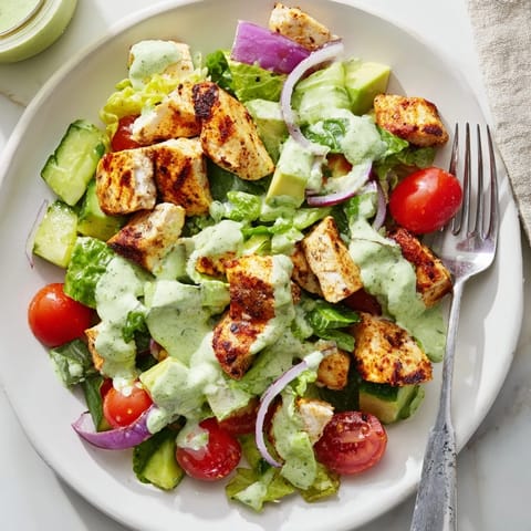 A vibrant bowl of Avocado Ranch Chicken Salad, featuring juicy diced chicken, crisp vegetables, and a rich avocado-based ranch dressing.  