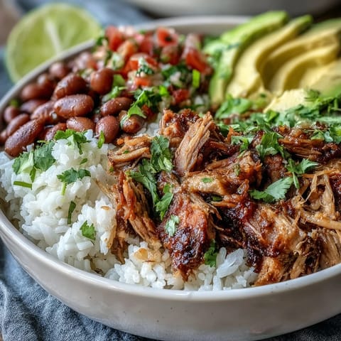 A hearty gluten-free Carnitas Bowl featuring tender pork carnitas, seasoned pinto beans, and vibrant toppings, perfect for a satisfying weeknight Mexican dinner.