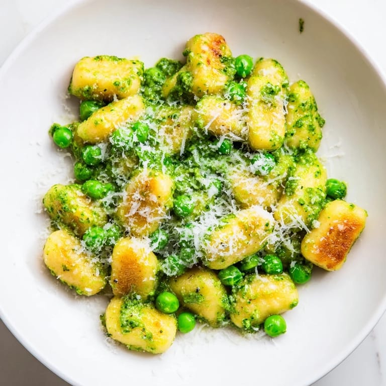 The savory Pesto Pea Gnocchi Skillet steams gently, showcasing sweet peas and fragrant basil pesto clinging to each bite.