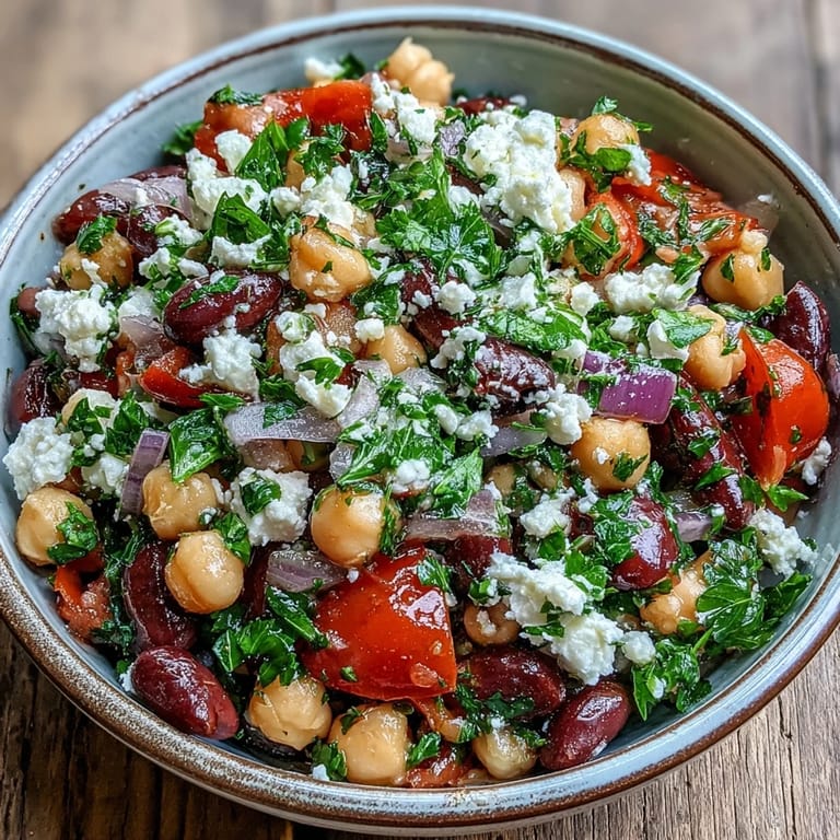 A close-up of vibrant Divorce Salad with red onions, parsley, and a glistening olive oil dressing.