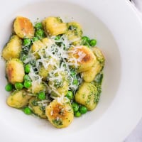 Golden, crispy pan-fried gnocchi are tossed with vibrant basil pesto and sweet green peas in this savory skillet.  